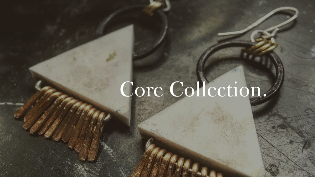 A pair of antler triangle dangle earrings with the words "core collection," written over the top of the photo